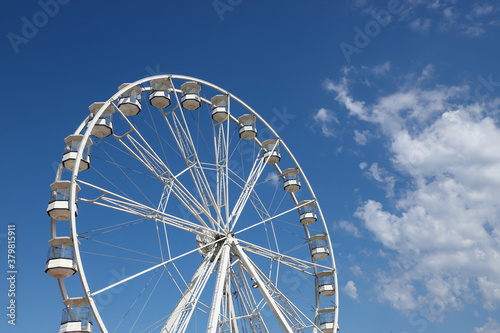 White ferris wheel against a blue sky background