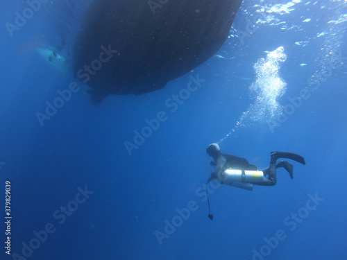 Submarinista buceando con barco en la superficie de fondo