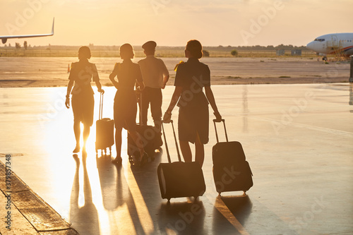 Bright evening sunlight in the airport and crew members walking