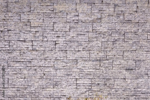 A grey wall with a texture of bricks looking rough