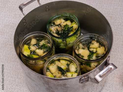 jars of vegetables in a large aluminum pan. pasteurization of canned vegetables