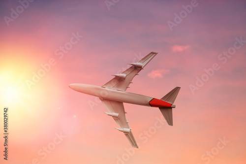Airplane flying in sky at sunrise. Air transportation