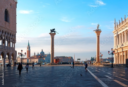 Morning scenery of St Mark's Square (Piazza San Marco) in Venice, with Lion of Venice & St Theodore statues on columns, Doge Palace by the square & tower of San Giorgio Maggiore Church in background