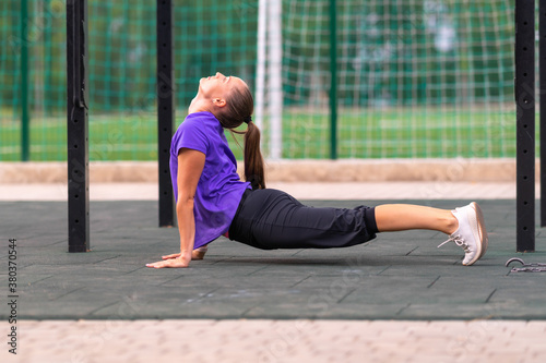 Young athletic woman practicing yoga outdoors