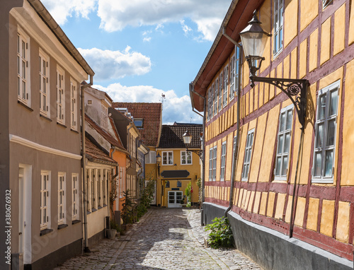 Cobblestone street with slanted houses at the old town of Aalborg, Denmark