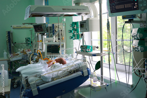 Reviving apparatus attached to a baby lying on a hospital bed