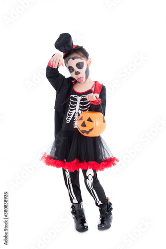 Full length of asian girl in halloween skeleton costume holding pumpkin bucket standing isolated over white background .
