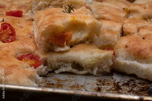 Italian focacchia mede with rosemary, tomato and hot pepper, on a baking tray