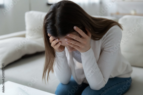 Unhappy young Caucasian woman feel distressed suffer from miscarriage or abortion alone at home. Upset sad lonely millennial female struggle with personal mental psychological problem, need help.