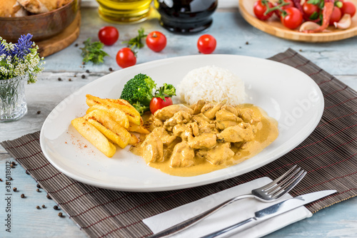 Chicken Curry Sauce. Served with rice. Natural wooden background.