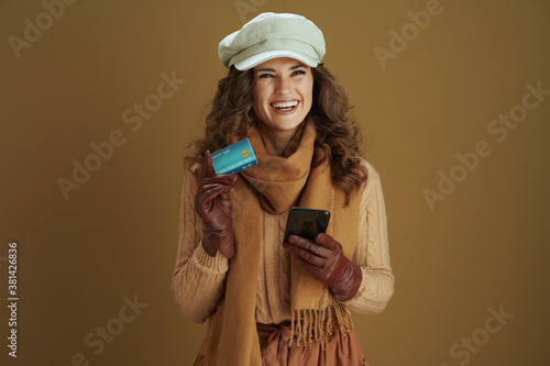 happy stylish woman shop online against brown background