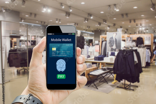Digital mobile wallet concept.Hands holding mobile phone on blurred fashion store as background
