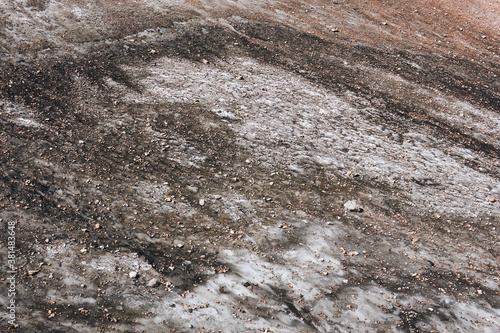 surface of a melting mountain glacier covered with stones and rubble