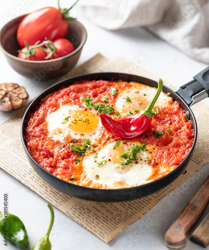 Shakshuka, fried eggs with vegetables in a frying pan, traditional israeli cuisine