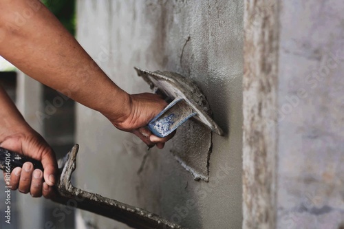 Concrete plasterers to create industrial workers background walls with plastering tools.