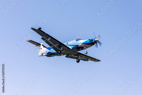 Single-engine blue airplane flying on a sunny day in the blue sky. The plane rises after takeoff.
