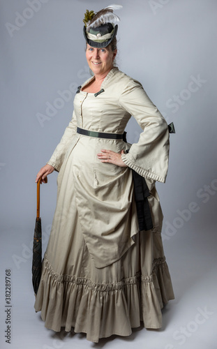 A middle-aged woman in a Victorian costume holding a parasol