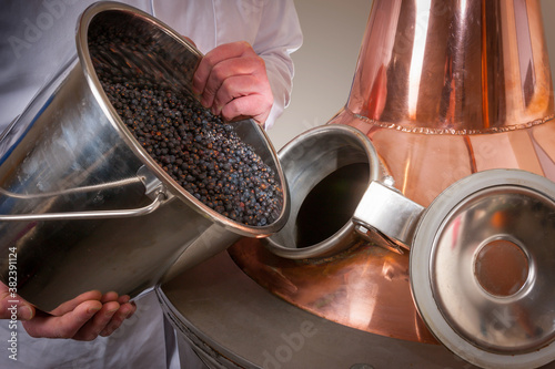 Juniper berries being added to a copper gin still