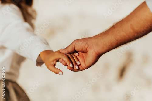 Lovely couple holding hands on white background. Couple together outdoors in love and romantic relationship. Close-up of hands.