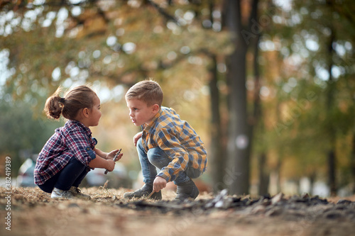 Brother and sister playing in the woods; Healthy childhood concept