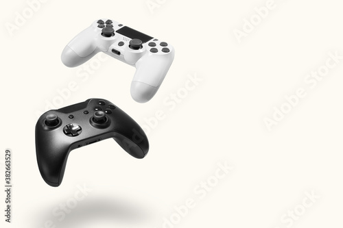 White and black game controllers on white background