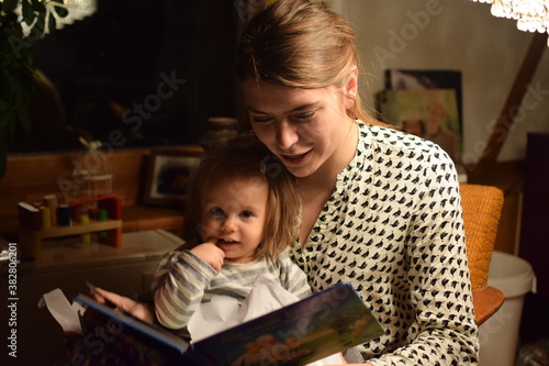 Mutter liest ihrer Tochter abends aus einem Buch vor.