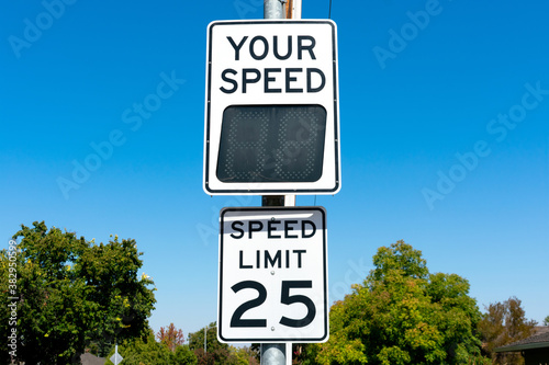 Your Speed, a radar speed sign that displays vehicle speed as motorists approach. 25 mph speed limit sign in residential neighborhood