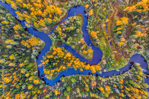 Winding river with island in autumn forest aerial top view