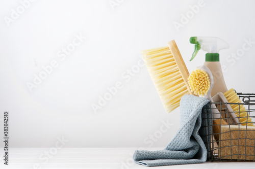 Eco brushes, sponges and rag in cleaning basket. Cleaner concept on white background