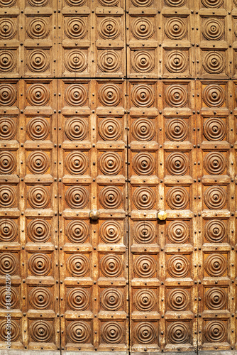 Closeup of an ancient studded wooden door with square and circle shapes, full frame. Verona downtown, Veneto, Italy, Europe