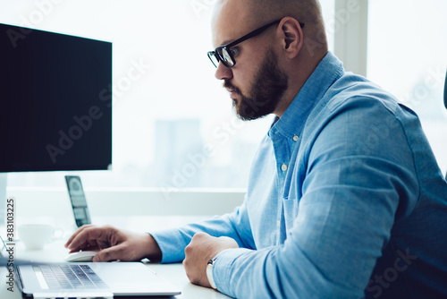 Serious man using laptop in office