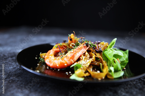 lunch dinner dish meal in a gourmet restaurant. food fish elegant gourmet plate. sea seafood shrimp on black plate