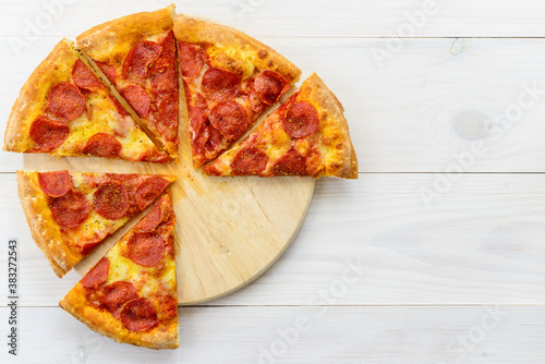 Slices of pepperoni pizza on a wooden table. Horizontal orientation, top view, copy space.