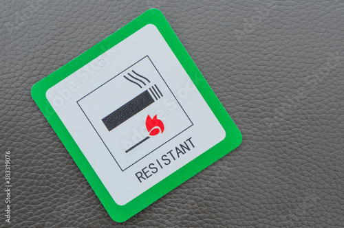 Fire resistant sign on grey leather sofa.