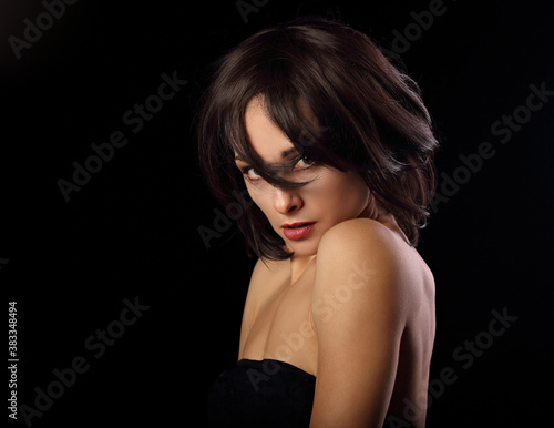 Alluring portrait of short bob hair style woman looking down on black background. Closeup portrait.