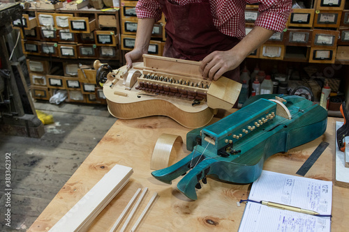 Craftsman makes a hurdy-gurdy (wheel vielle) in workshop.