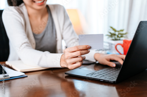 young woman hands holding credit card and using laptop for online shopping. Credit card buy or paymaent conceptl.
