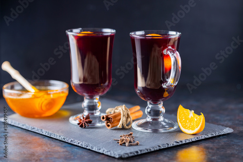 Mulled wine on a slate board. Two glasses of hot mulled wine and ingredients. Christmas hot drink with wine and honey