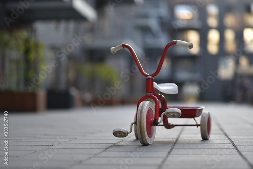 child three wheels bicycle in apartments yard