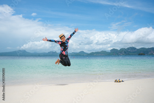 Happy asian woman jumping on the beach