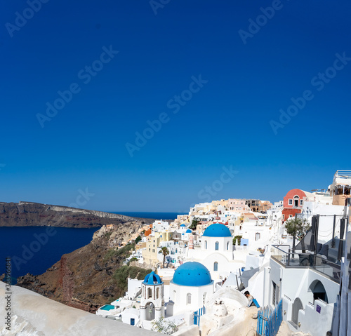 View of Santorini, with typical blue dome church, old whitewashed houses and caldera