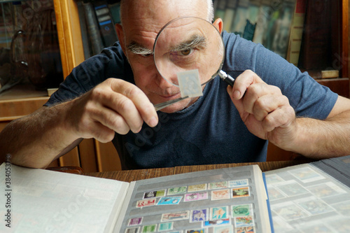  An elderly man examines a brand through a magnifying glass.