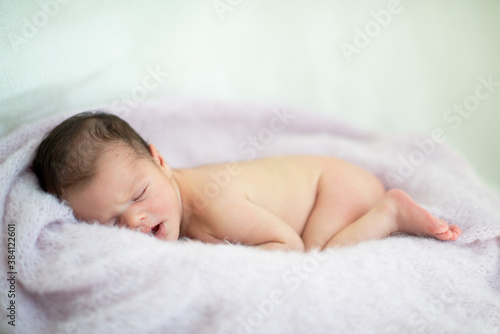 New born baby girl sleeps at home. Cute little kid's portrait