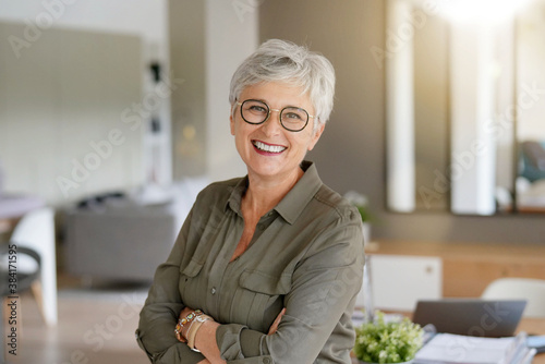 portrait of a beautiful smiling 55 year old woman with white hair