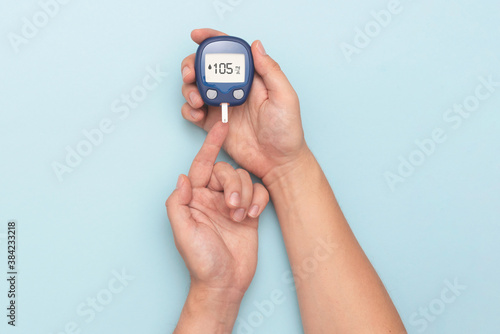 Man using glucometer, checking blood sugar level