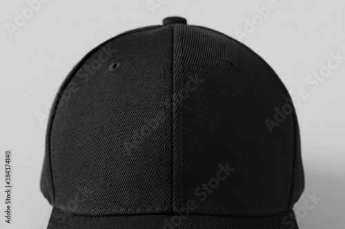 Black baseball cap mockup on a grey background, closeup.