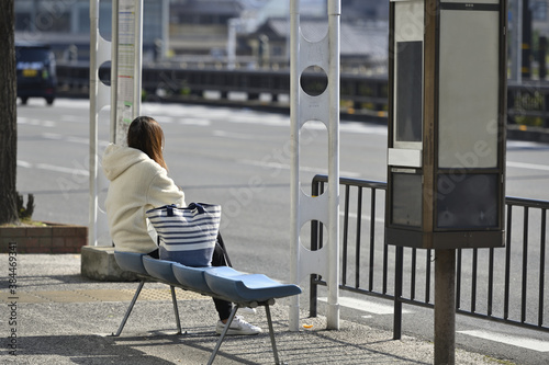 バス停でバスを待つ女性