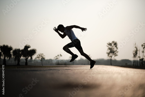 Silhouette young man jumping on the road during sun rise