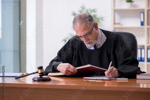 Old male judge working in courthouse