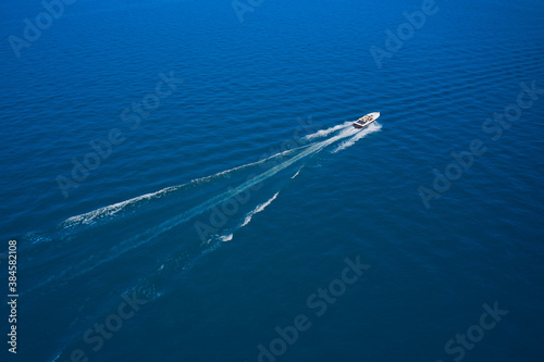 Aerial view luxury motor boat. Drone view of a boat the blue clear waters. Travel - image. Large speed boat moving at high speed side view.